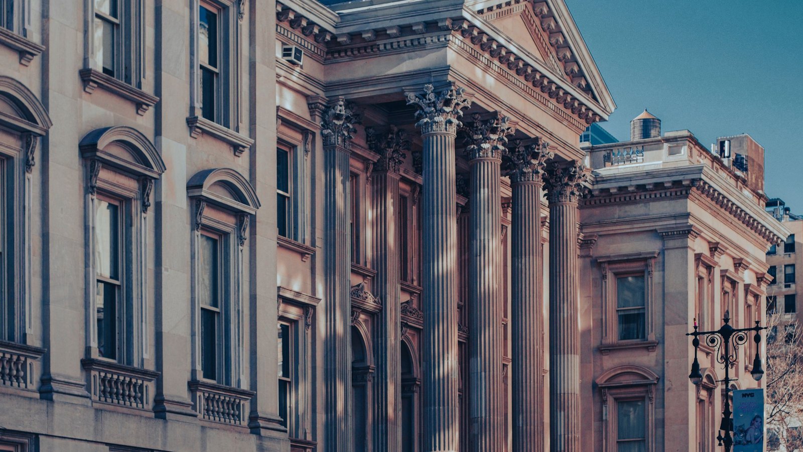 Neoclassical courthouse facade in warm late light, the building where a criminal defense firm's cases are heard.